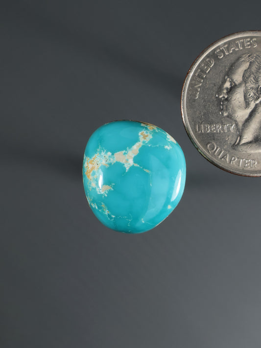Turquoise cabochon gemstone with gold-toned veining, round