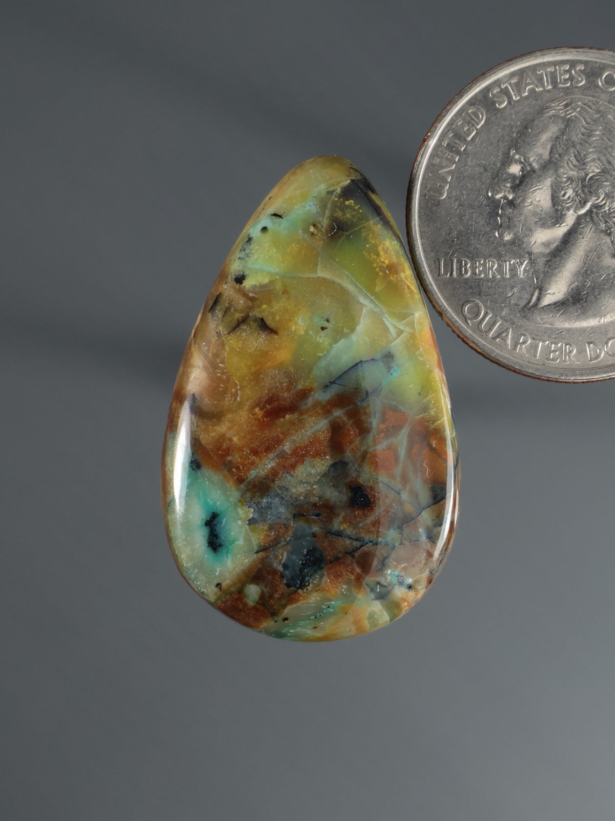 Teardrop cabochon with green, blue, and brown mottled stone