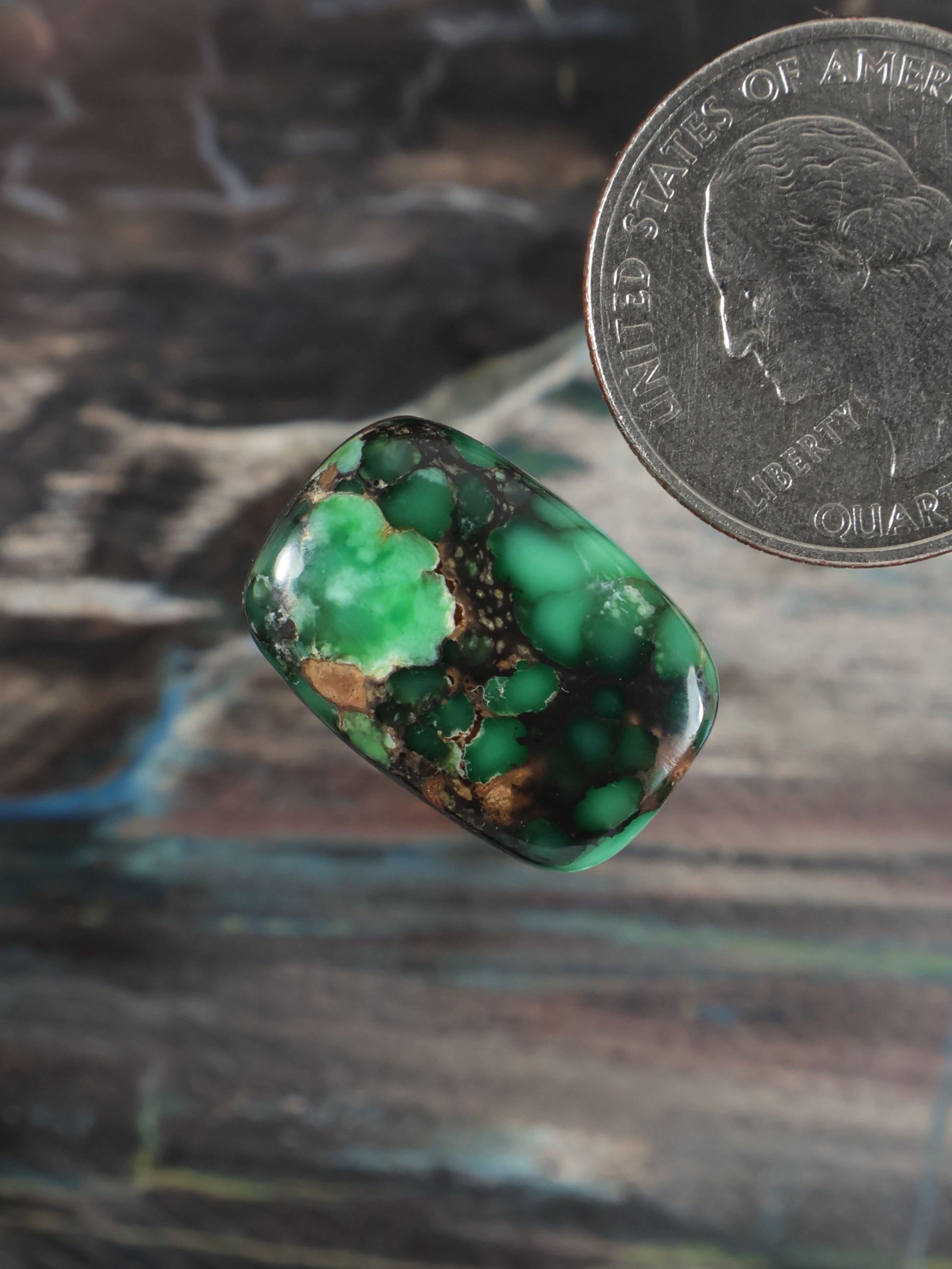 Rounded oval green variscite cabochon, mottled with dark matrix and tan spots