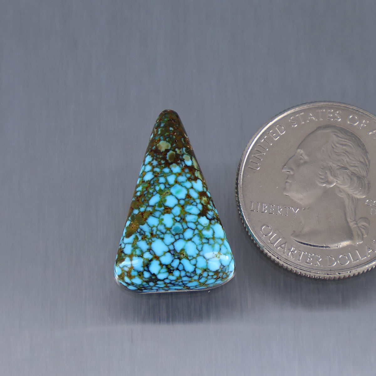 Triangular turquoise cabochon with red web matrix