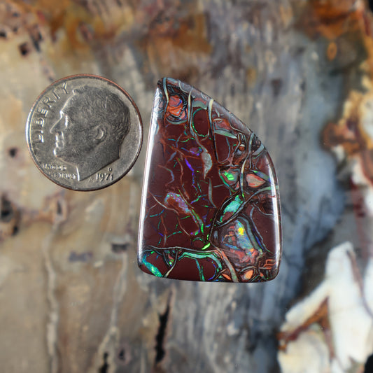 Marquise boulder opal cabochon with dark maroon base and bright green-blue flashes