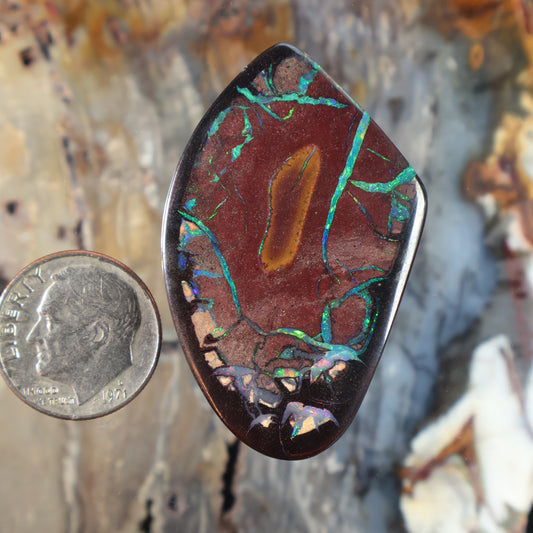 Teardrop boulder opal cabochon with red base and green-blue veining, polished bezel