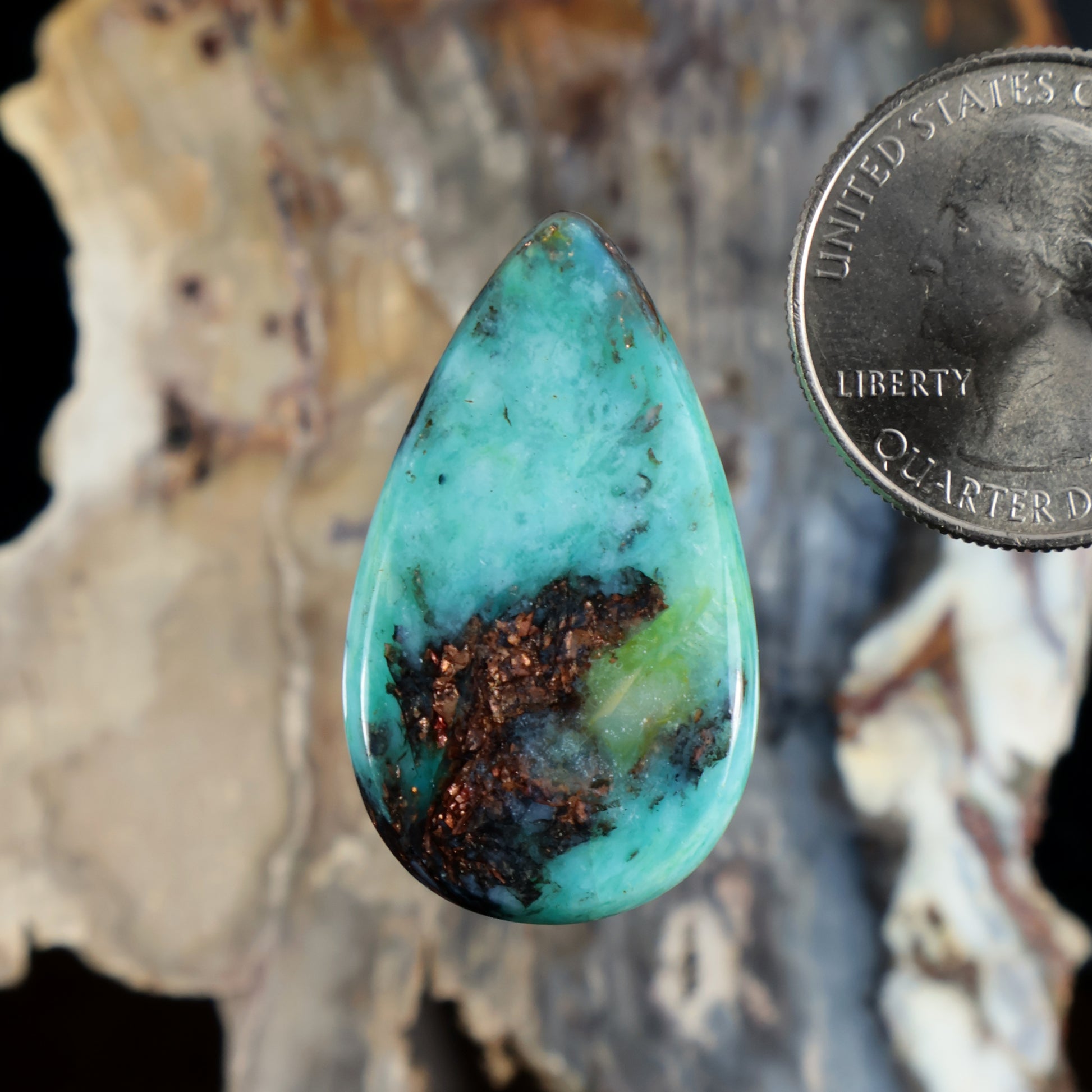 Turquoise teardrop cabochon with dark mineral veining, polished