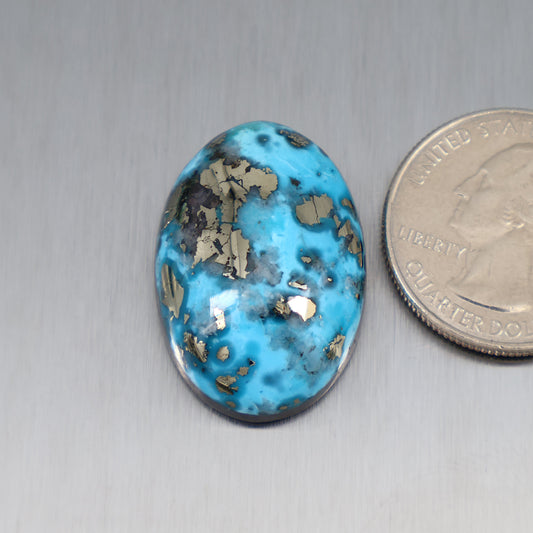 Turquoise oval cabochon with gold-brown matrix veining, glossy stone