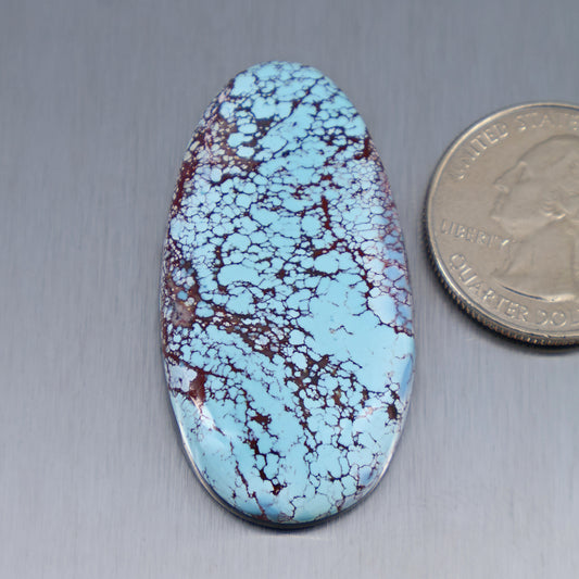 Oval turquoise cabochon with blue and maroon web pattern