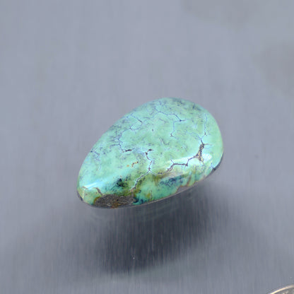 Turquoise cabochon gemstone, oval teardrop shape with web-like veining