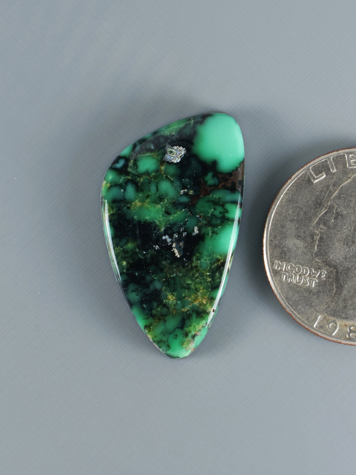 Green variscite cabochon, oval shape with dark matrix and polished surface