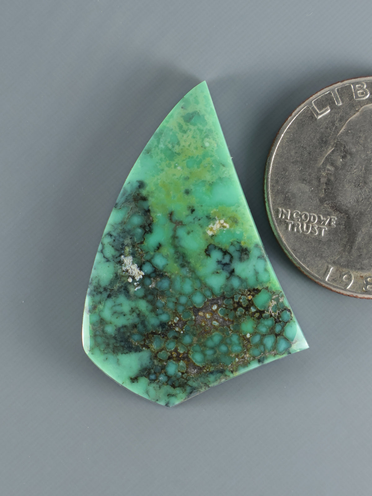 Variscite cabochon gemstone, triangular green with dark matrix webbing