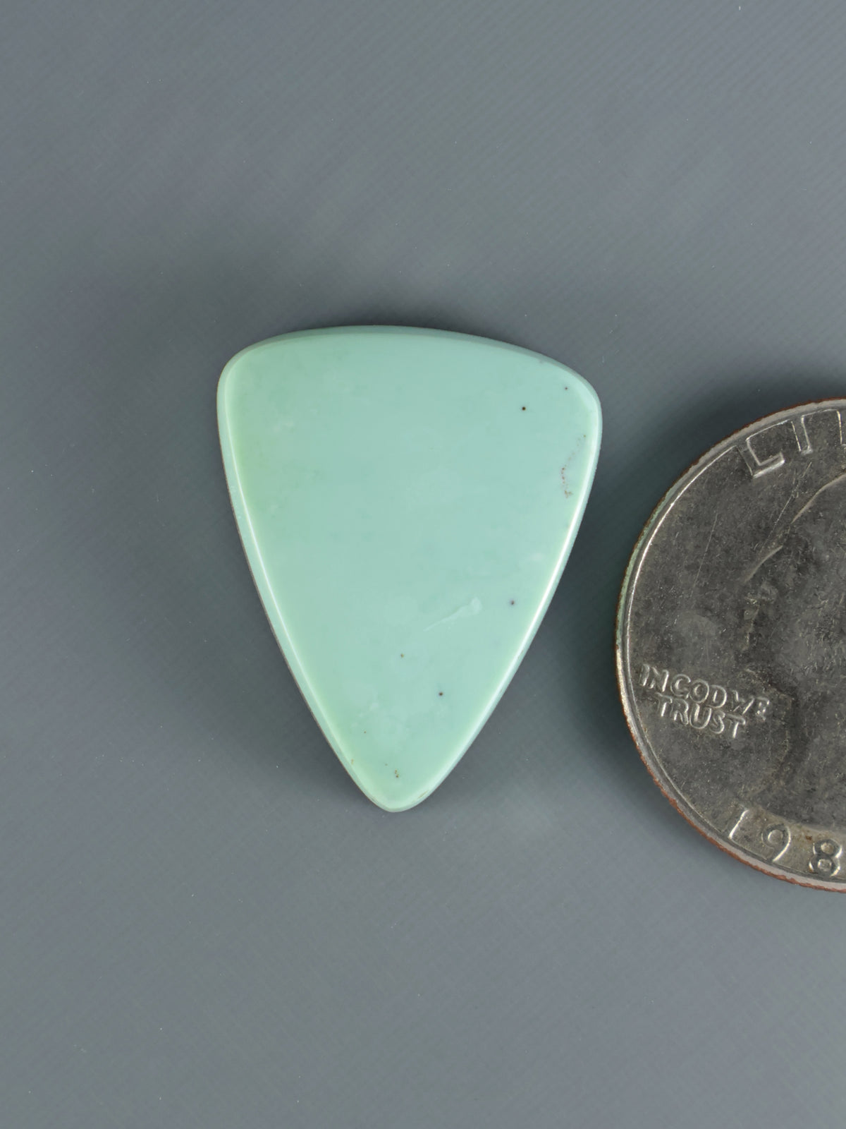 Mint green triangular variscite cabochon, polished gemstone, smooth domed face.