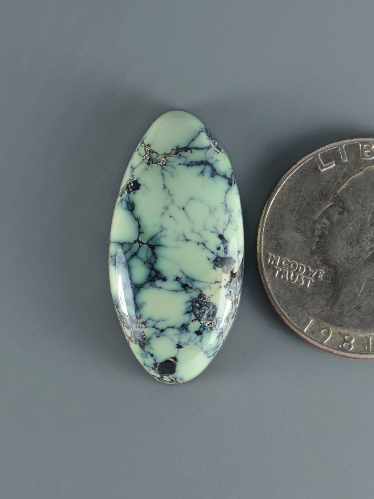 Oval variscite cabochon with pale green field and dark blue veined pattern