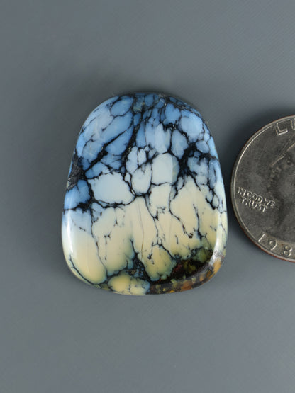 Blue and white marbled cabochon gemstone, oval with smooth polished surface