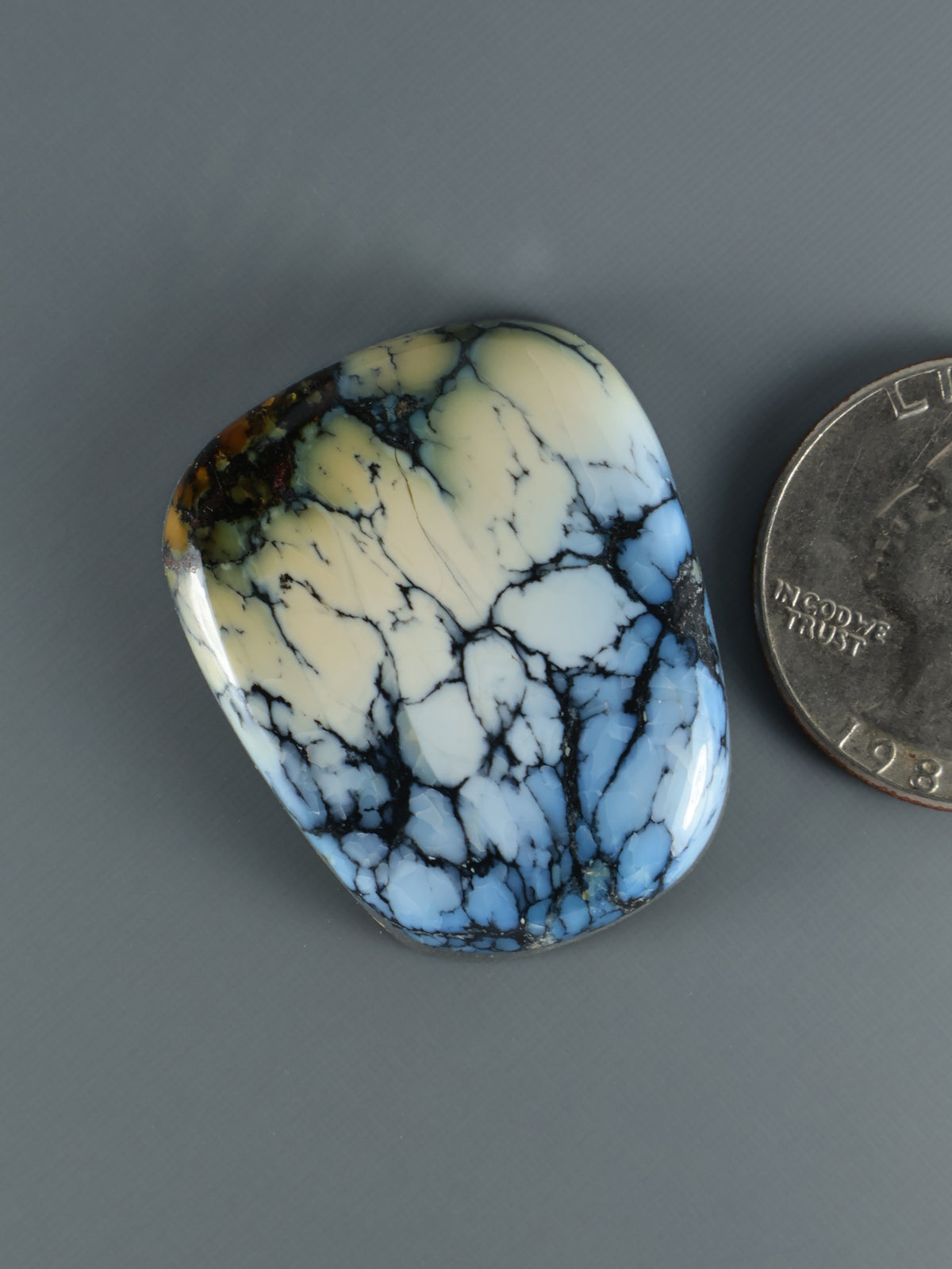 Blue and cream marbled cabochon gemstone, oval with smooth polished surface