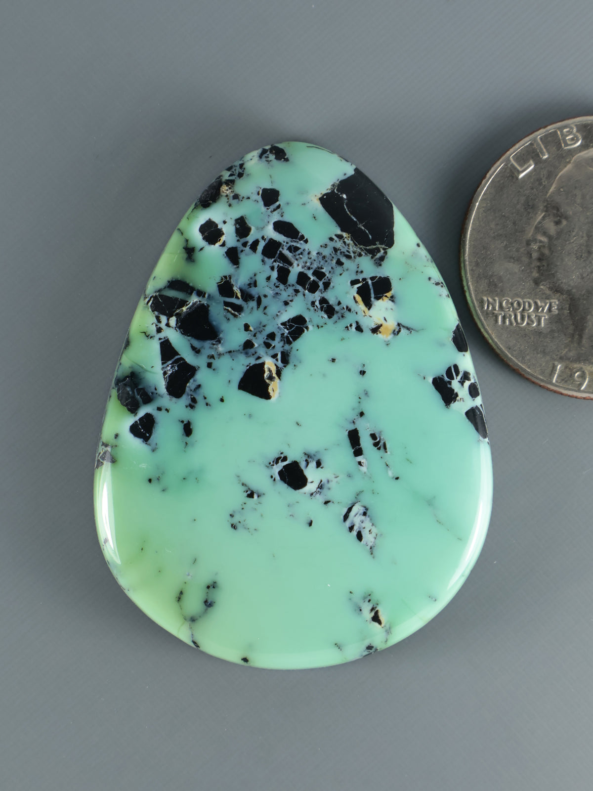 Green variscite cabochon with black and blue matrix, teardrop shape