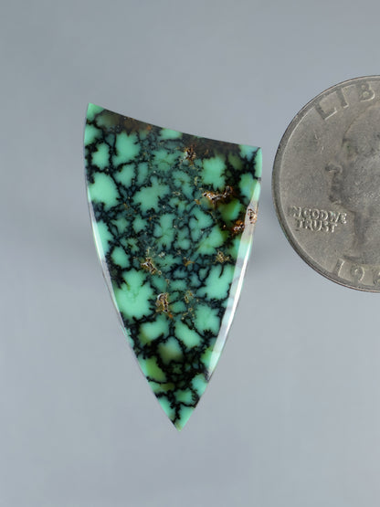 Triangular green variscite cabochon with dark web veins and small gold flecks
