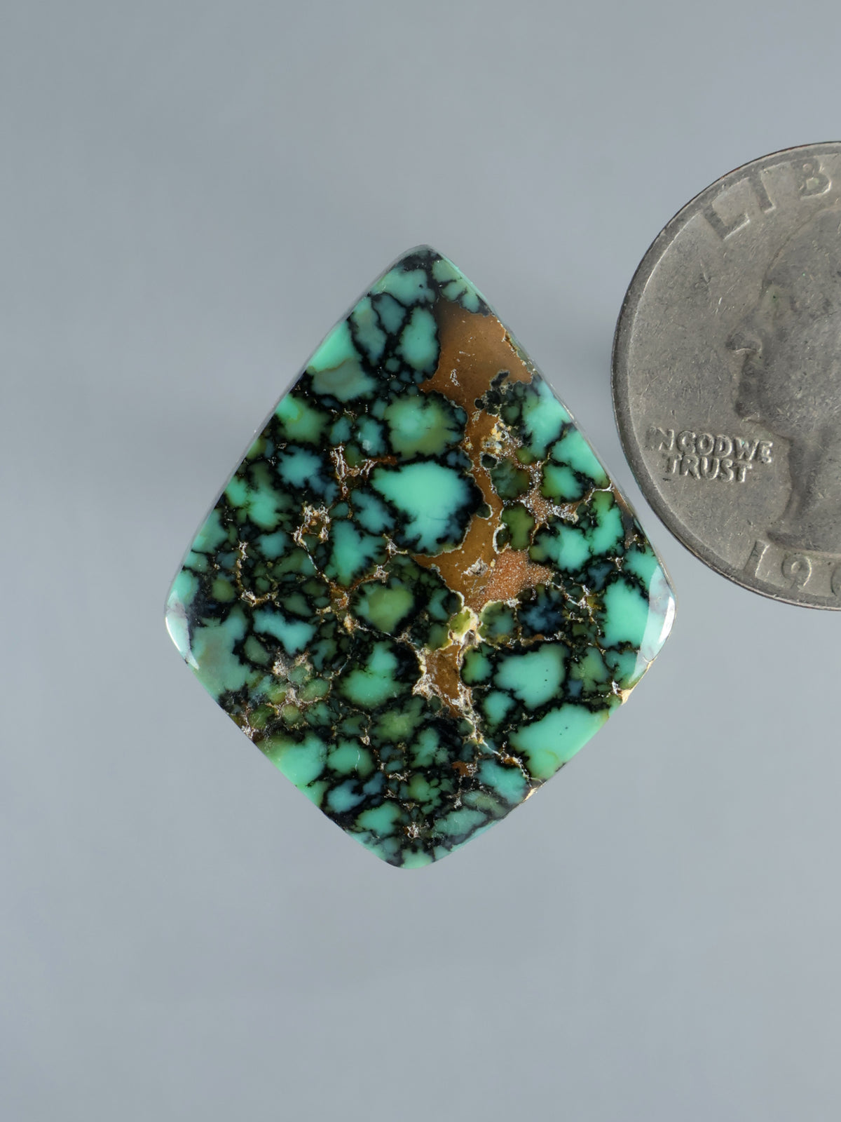 Variscite cabochon gemstone in turquoise, green, and brown with webbed pattern, teardrop