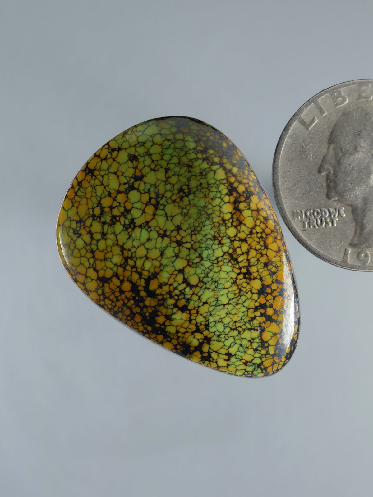 Turquoise and yellow cabochon gemstone with webbed pattern, oval teardrop cut