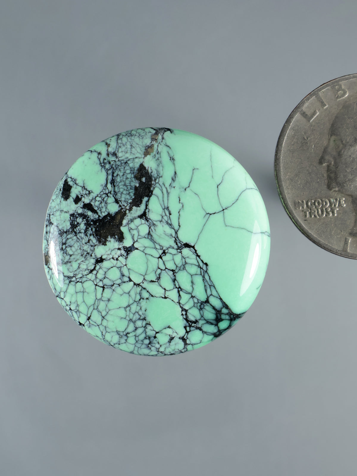 Variscite cabochon gemstone, mint green with dark web matrix veins, polished oval