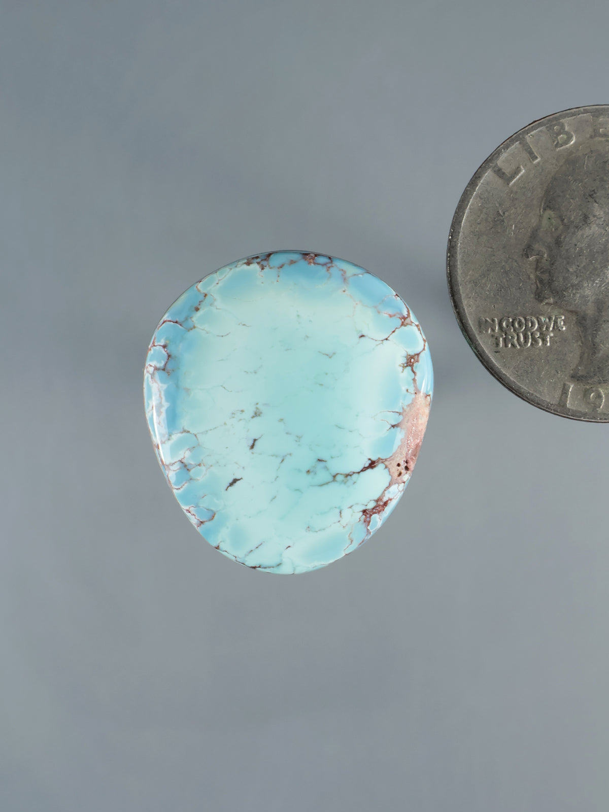 Oval turquoise gemstone cabochon with natural brown vein pattern