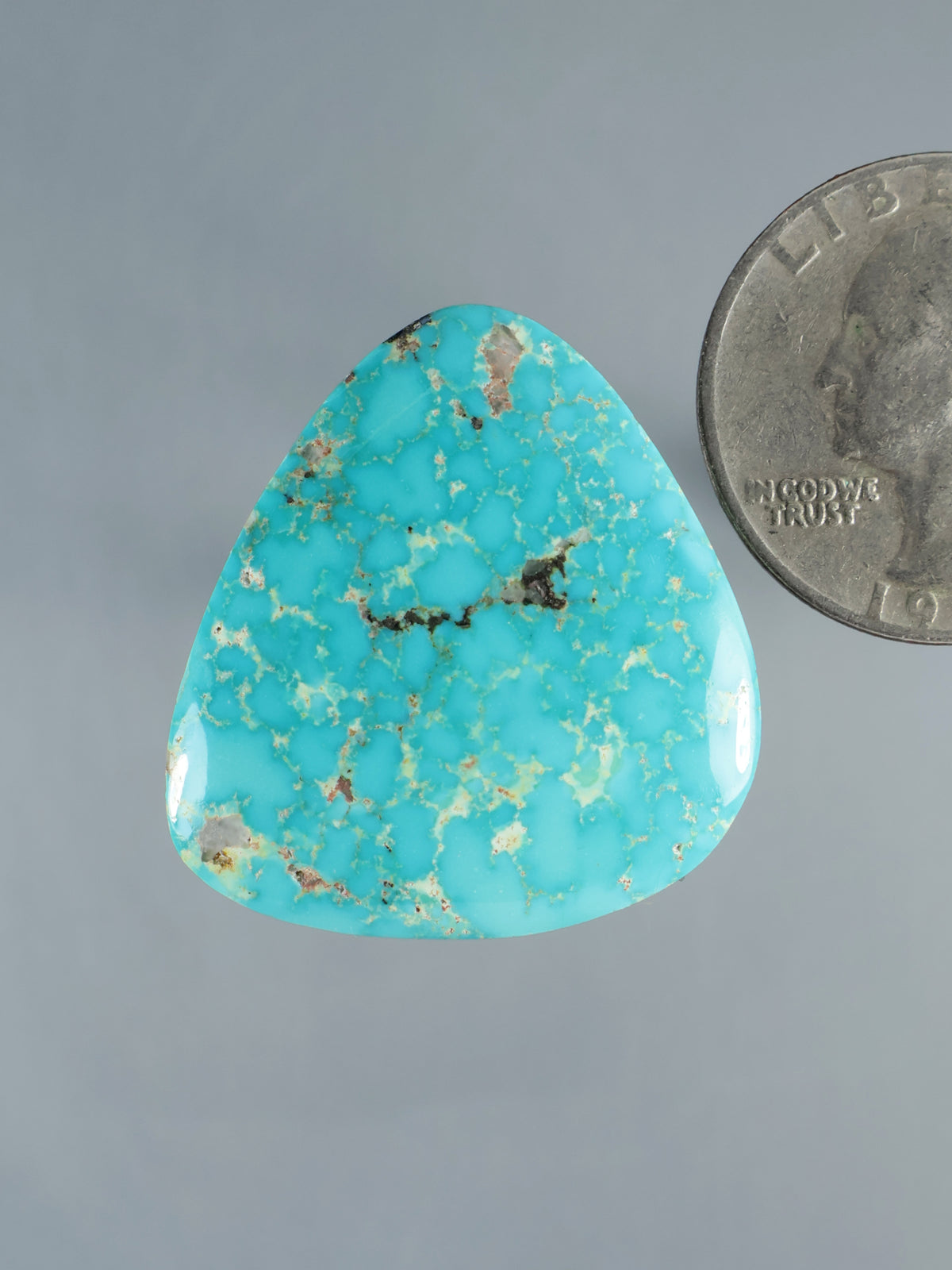 Turquoise cabochon stone in blue, teardrop shape with natural matrix