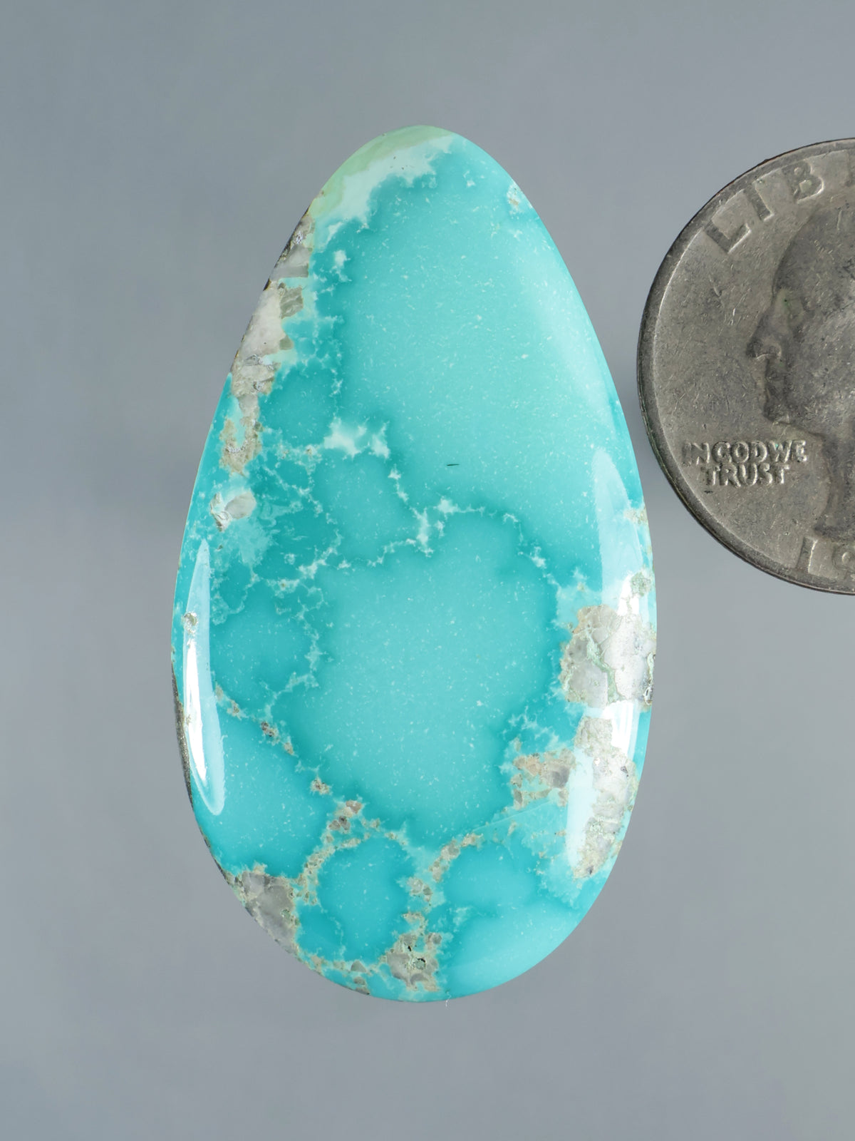 Turquoise cabochon gemstone, teardrop shape with white veined matrix