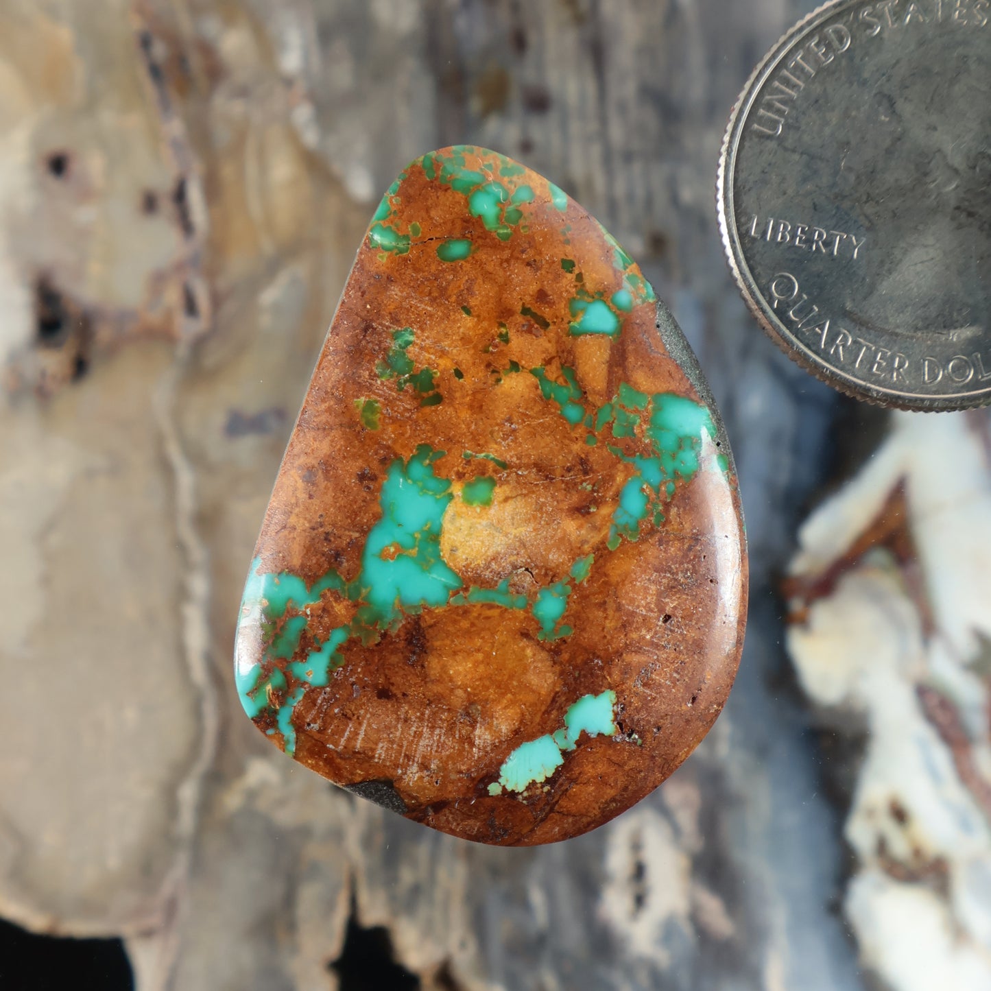 Turquoise cabochon gemstone, teardrop shape with orange-brown matrix and green-blue veins