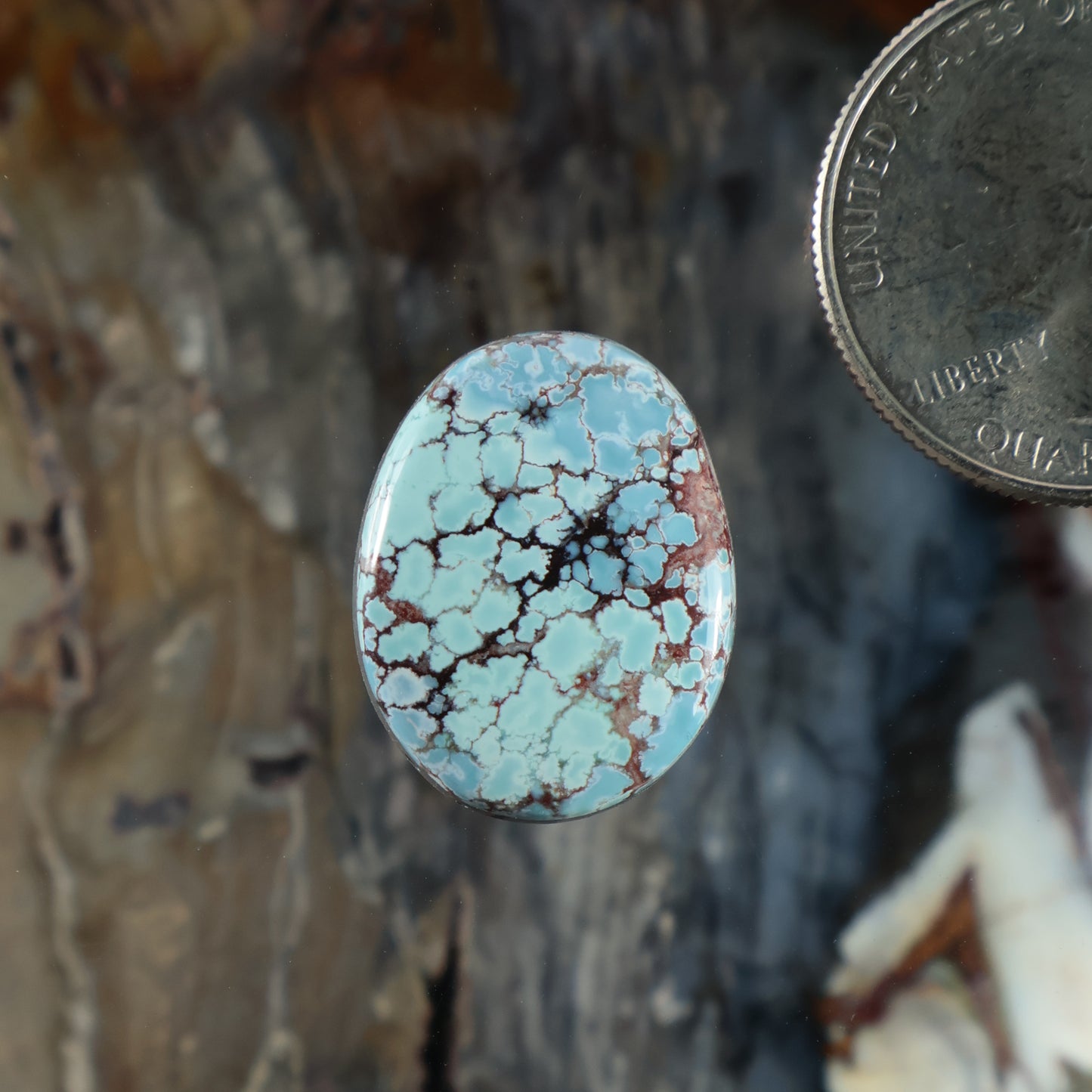 Oval turquoise cabochon gemstone with blue matrix and black veining