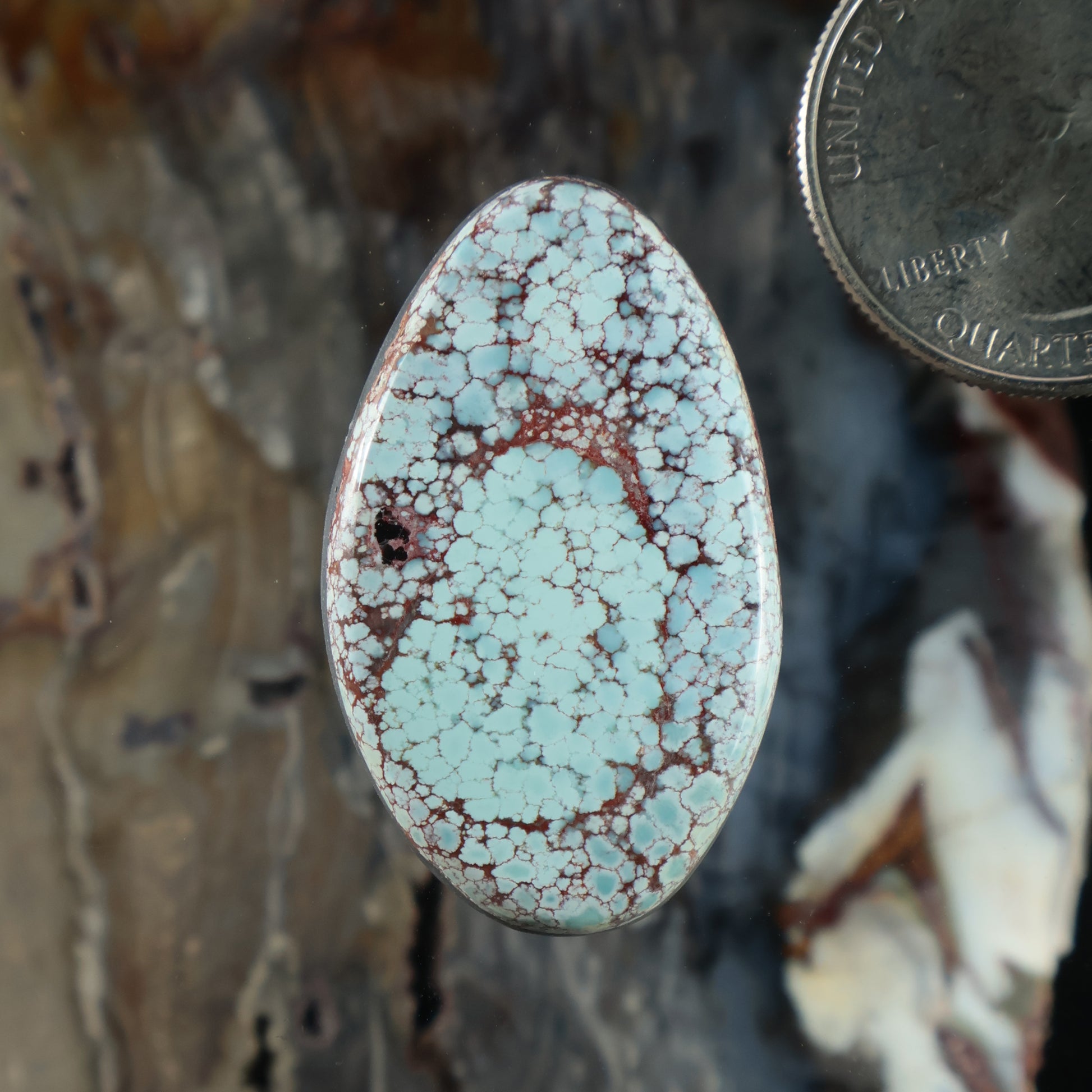 Oval turquoise cabochon with red-brown web matrix