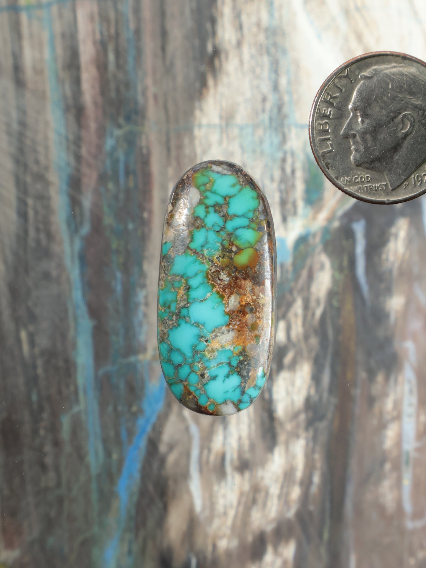 Oval turquoise cabochon gemstone with mottled blue and gold matrix