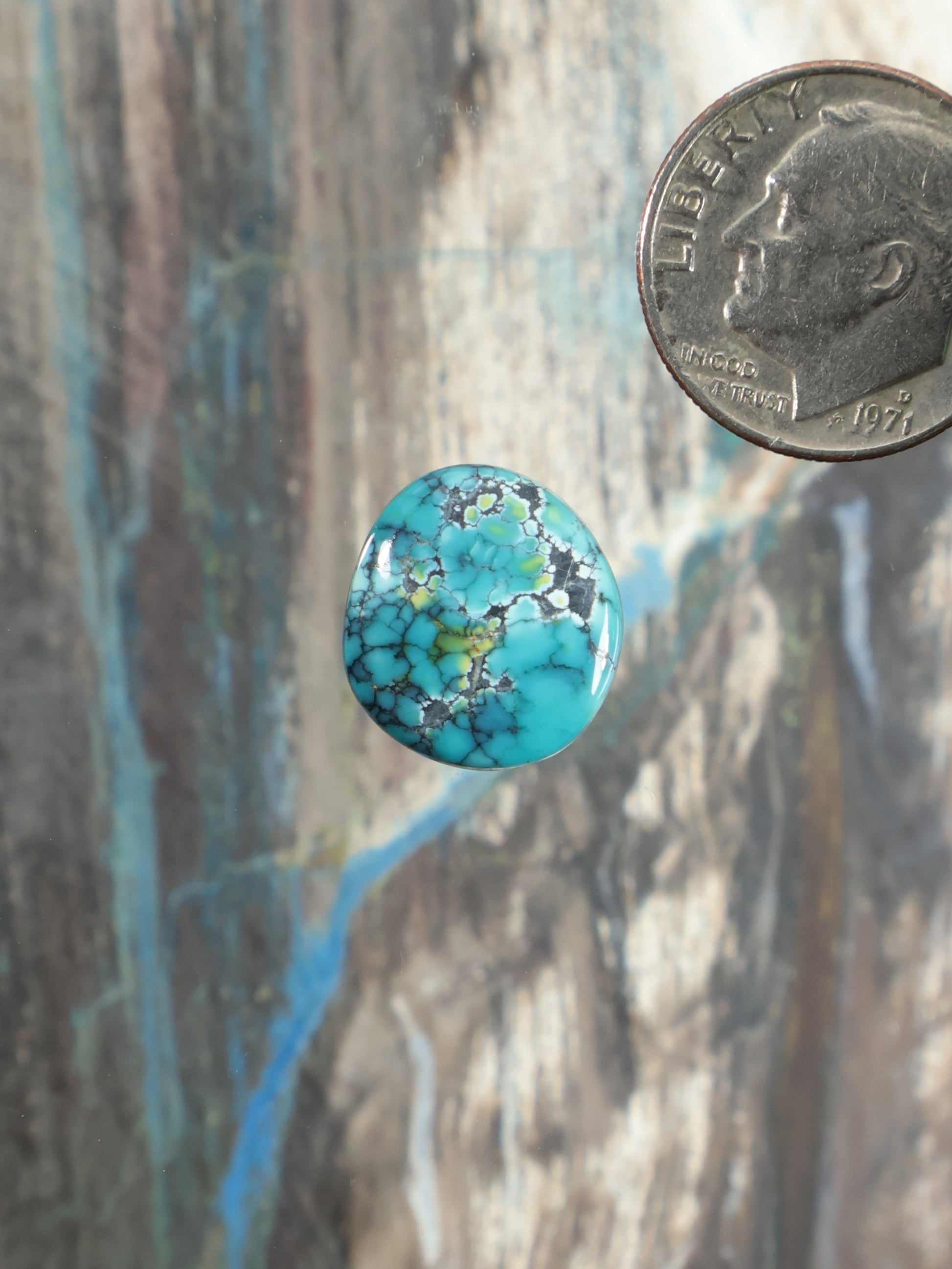 Round turquoise cabochon gemstone with blue-green matrix webbing, small size.