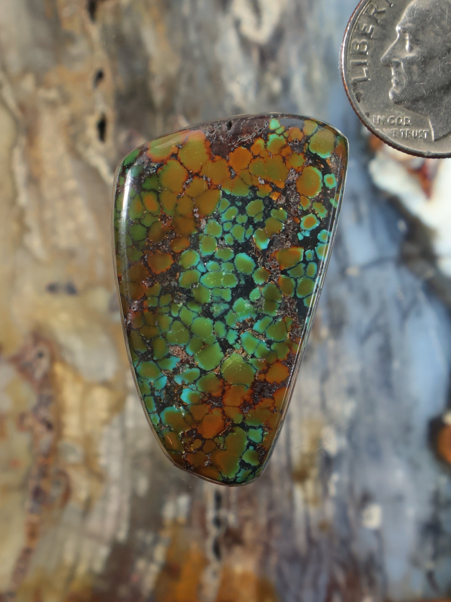 Turquoise cabochon gemstone in triangular setting with multicolor veining