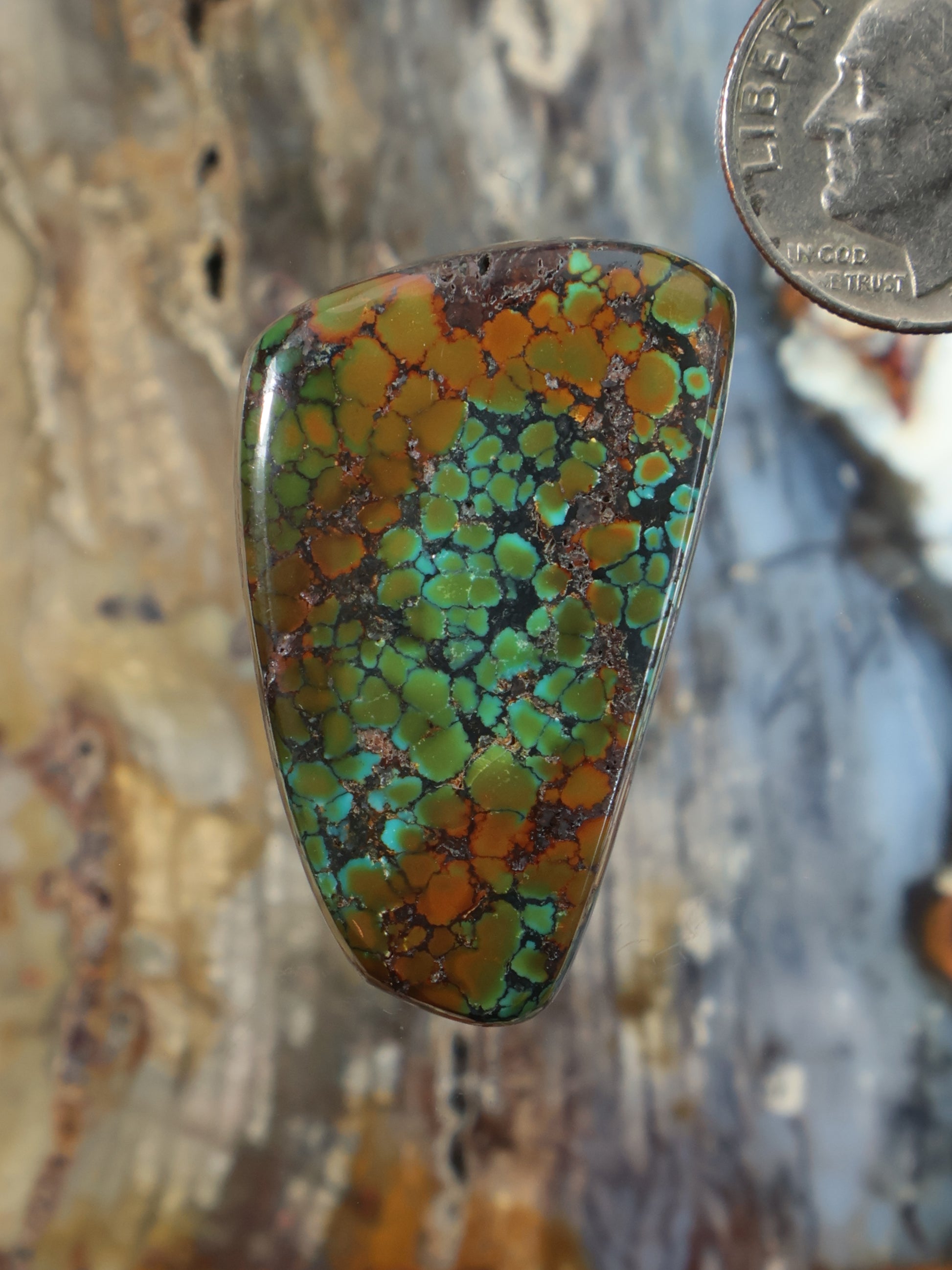 Turquoise cabochon gemstone in triangular setting with multicolor veining