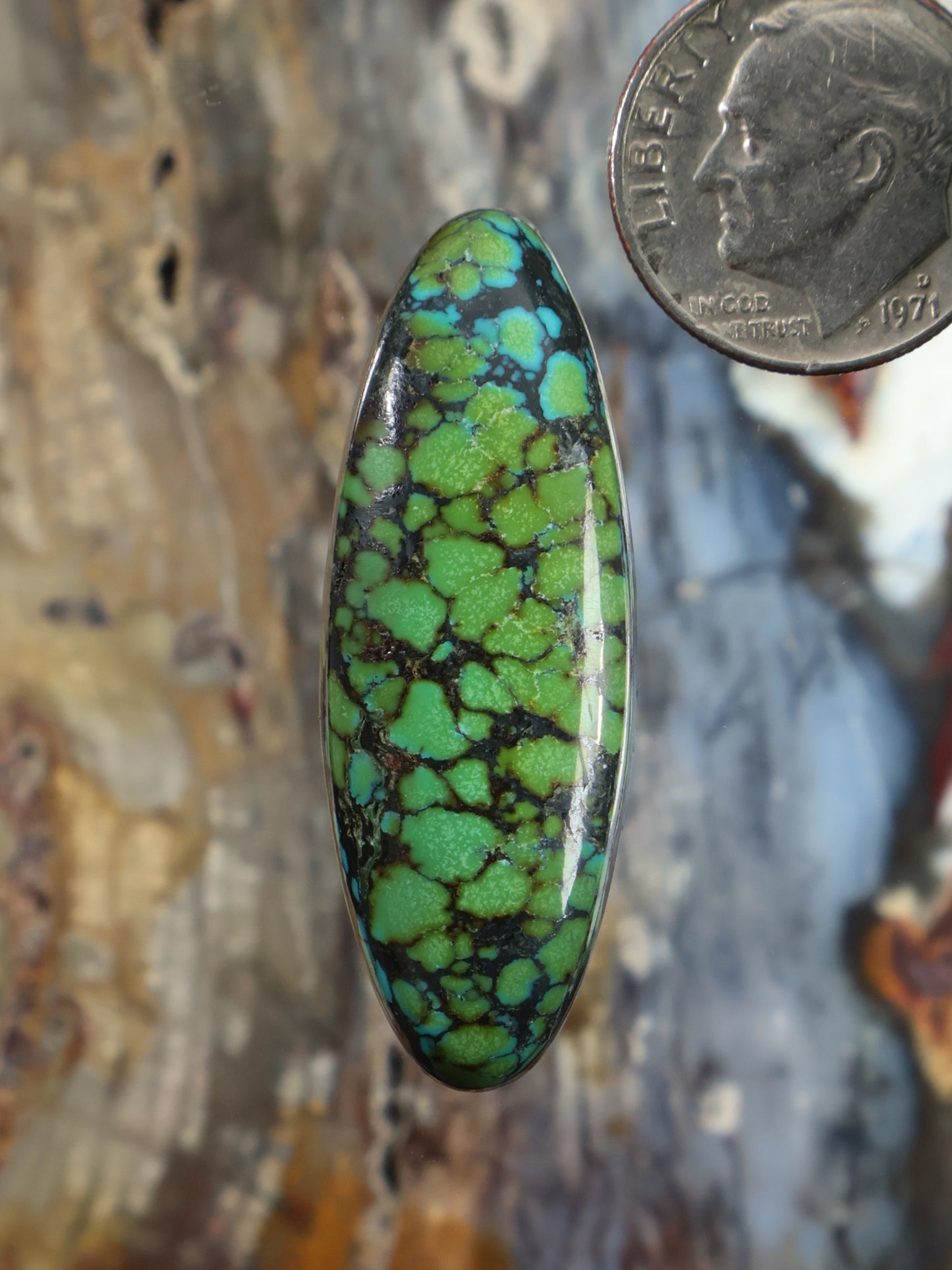 Oval turquoise cabochon with green matrix web and glossy glassy surface