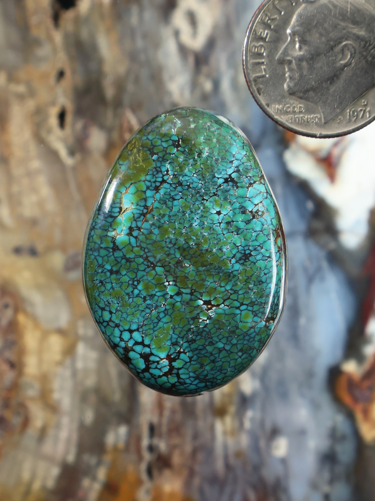 Turquoise cabochon gemstone, oval with bright blue-green cracked texture