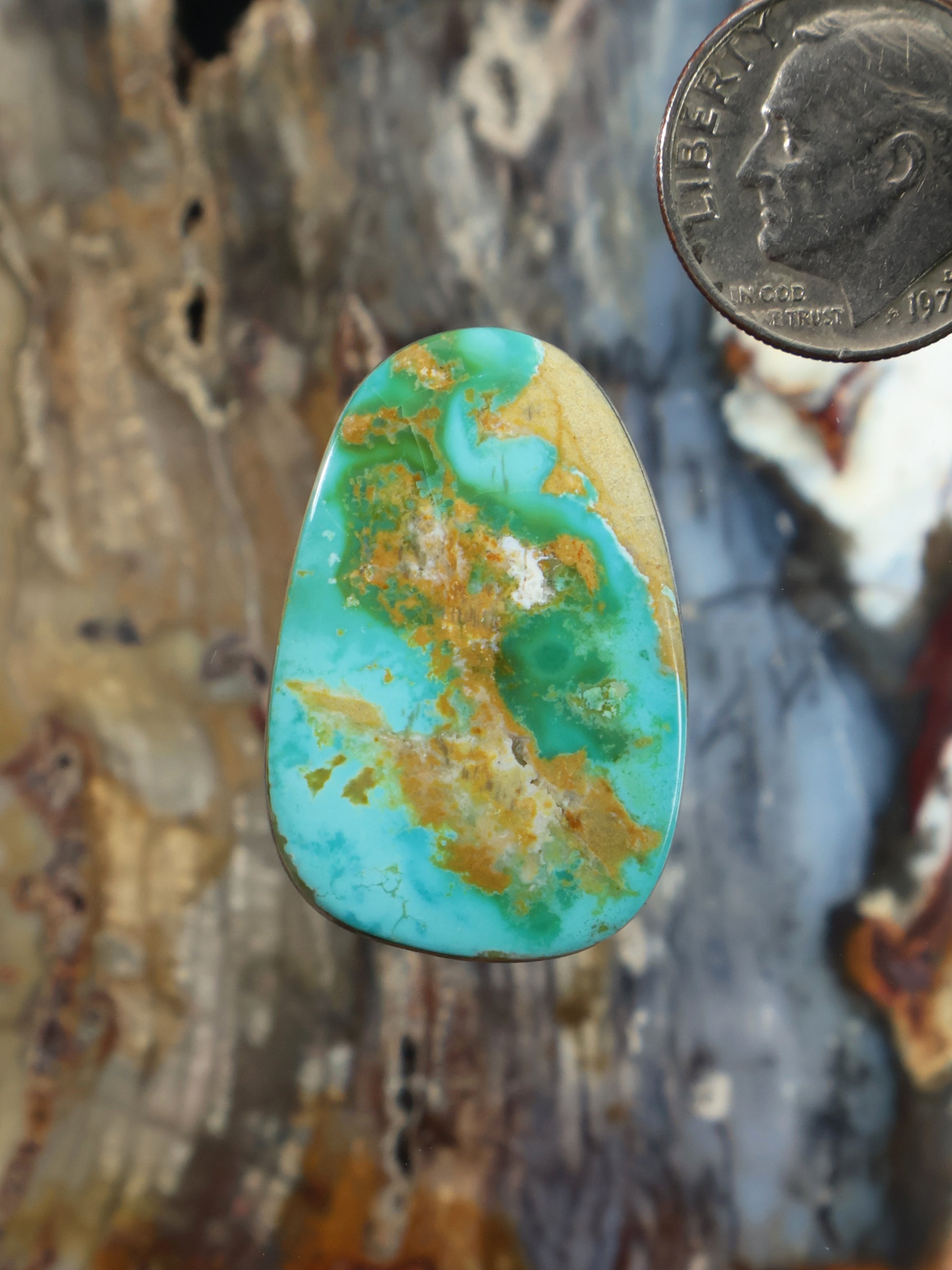 Oval turquoise cabochon gemstone with gold-brown matrix pattern