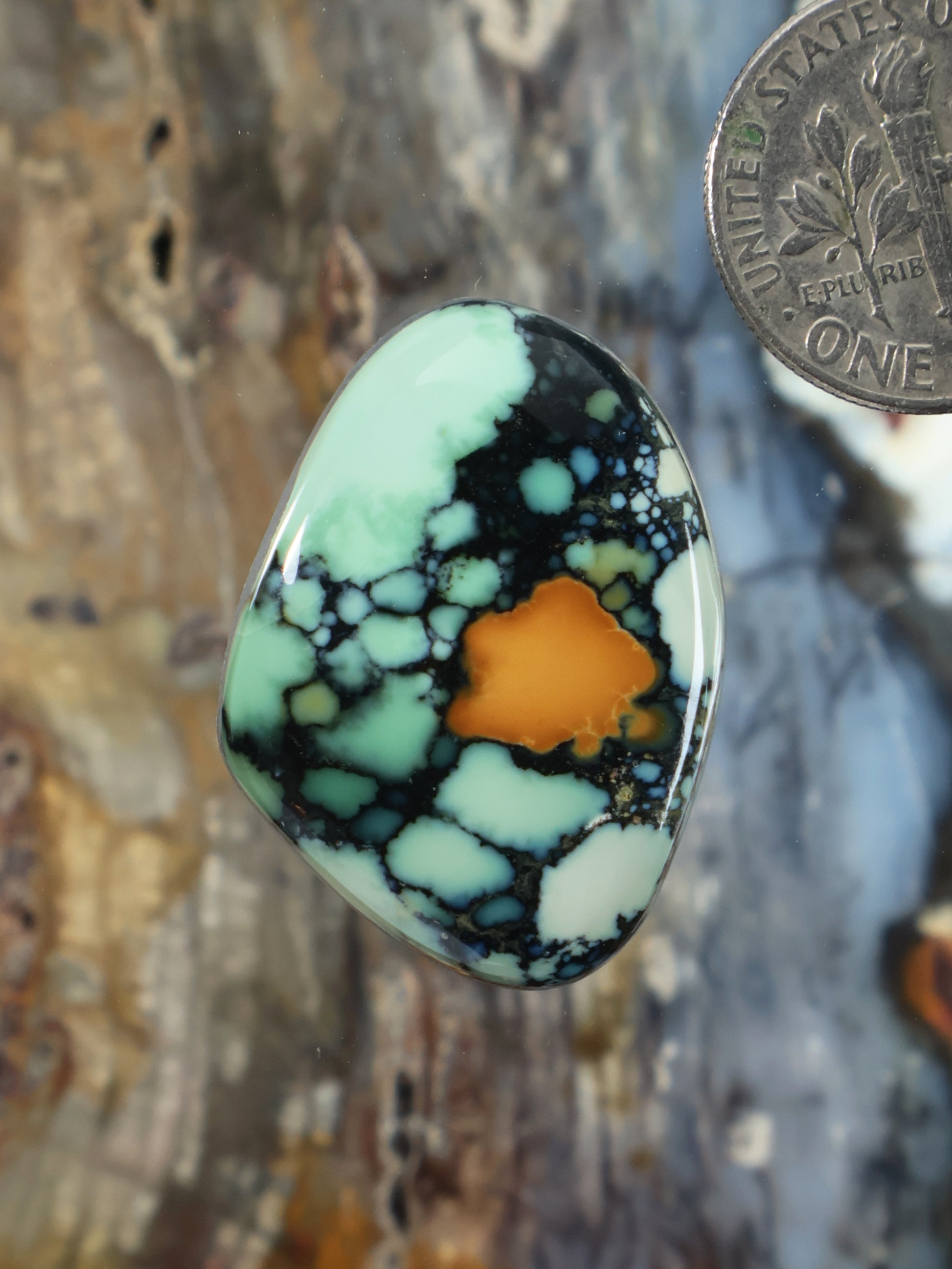 Oval variscite cabochon with mint green, dark web pattern, and warm orange center
