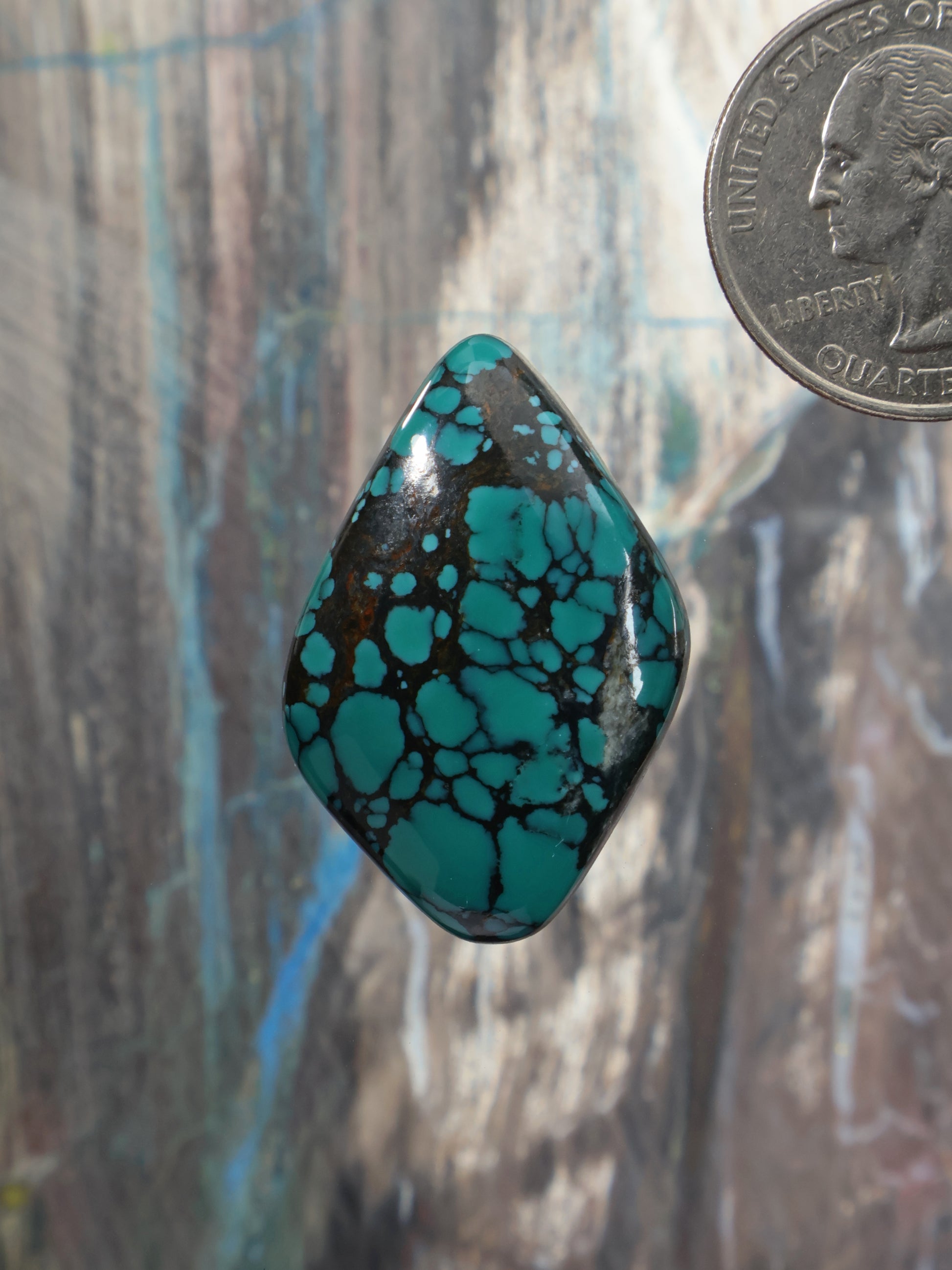 Turquoise cabochon gemstone, teardrop shape with dark matrix webbing