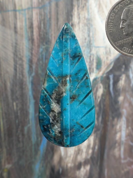 Carved turquoise feather-shaped cabochon in bright blue with dark mineral matrix