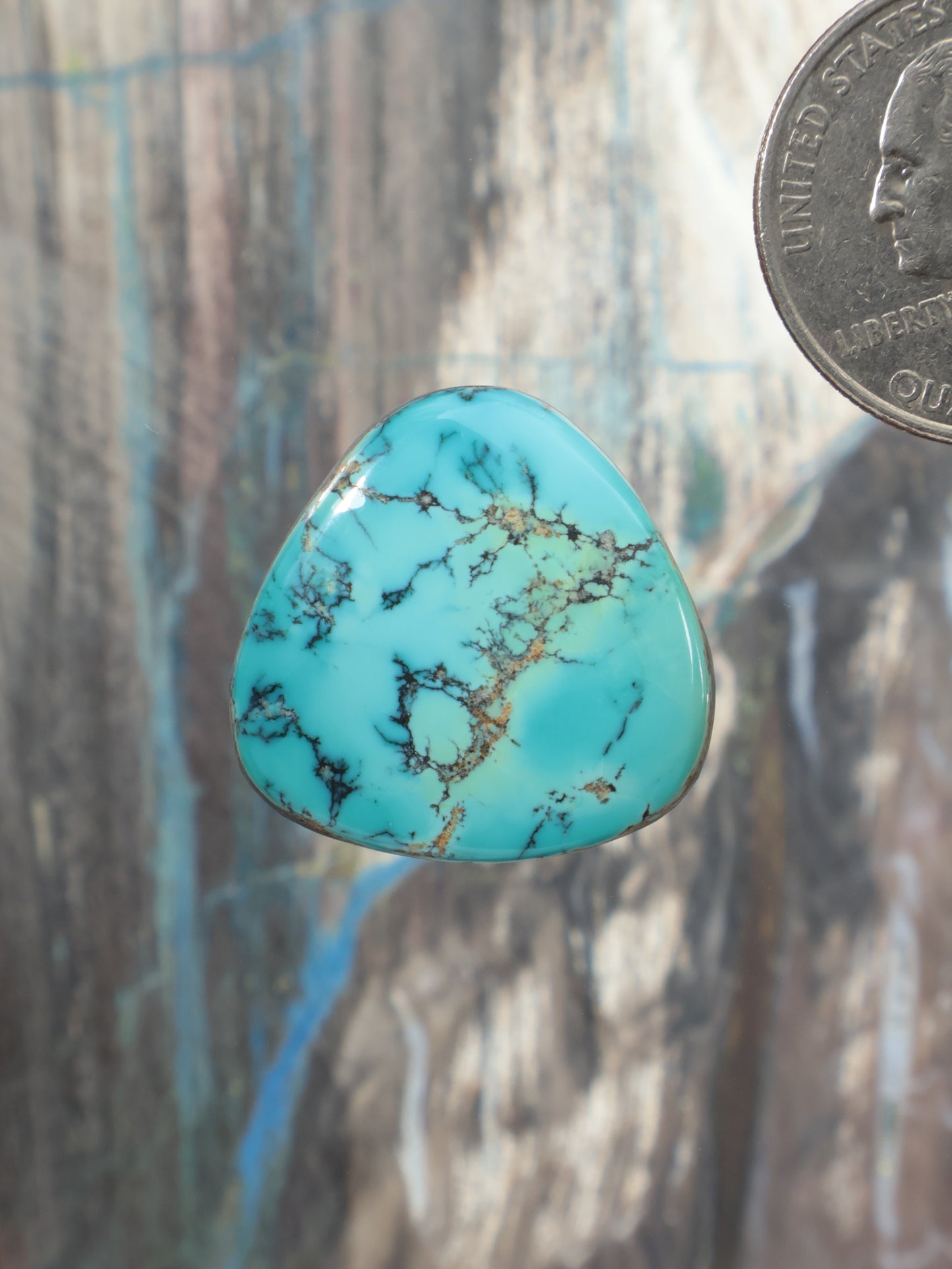 Turquoise cabochon gemstone with gold-brown matrix, teardrop shape, domed surface