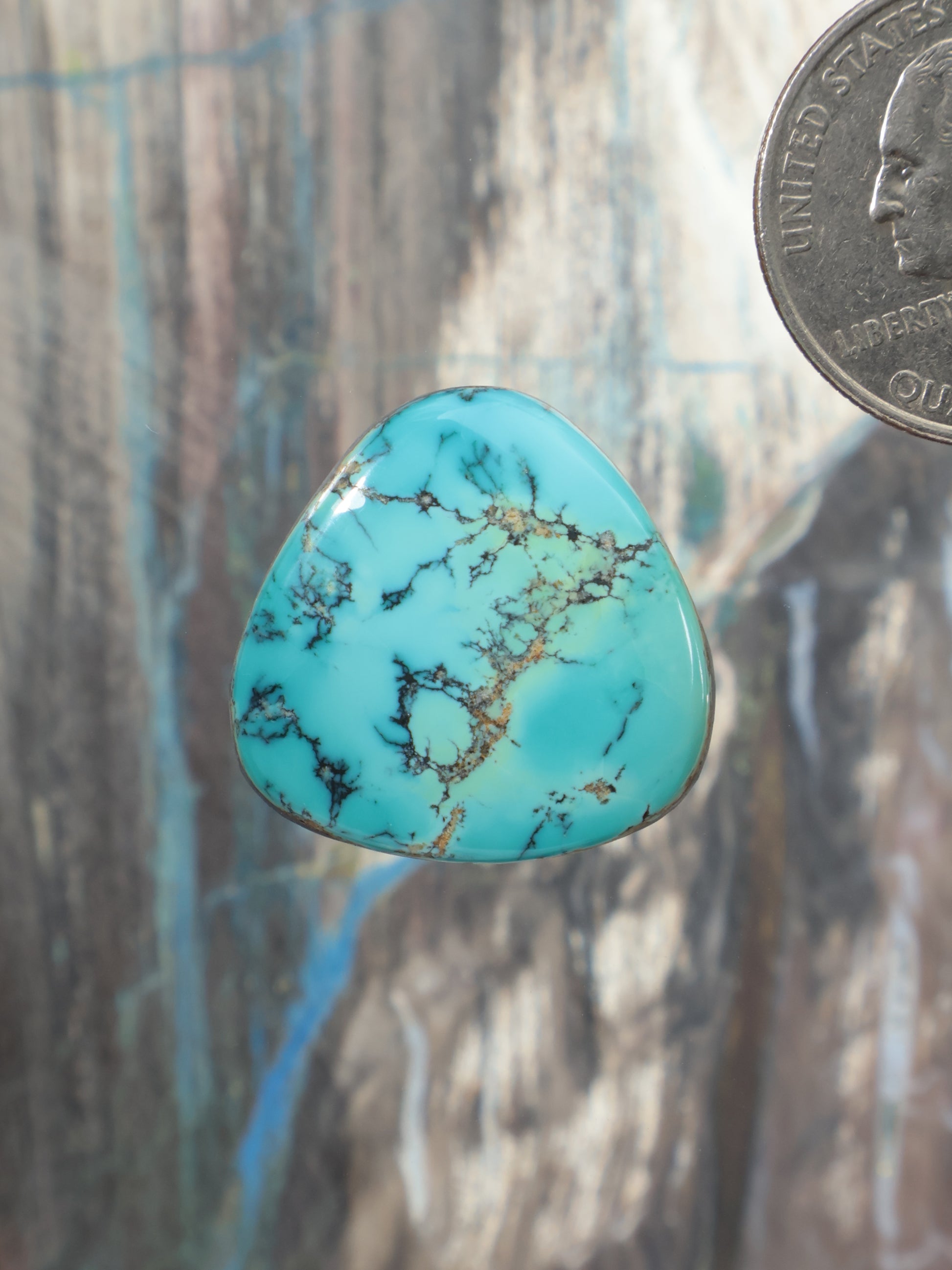 Turquoise cabochon gemstone with gold-brown matrix, teardrop shape, domed surface