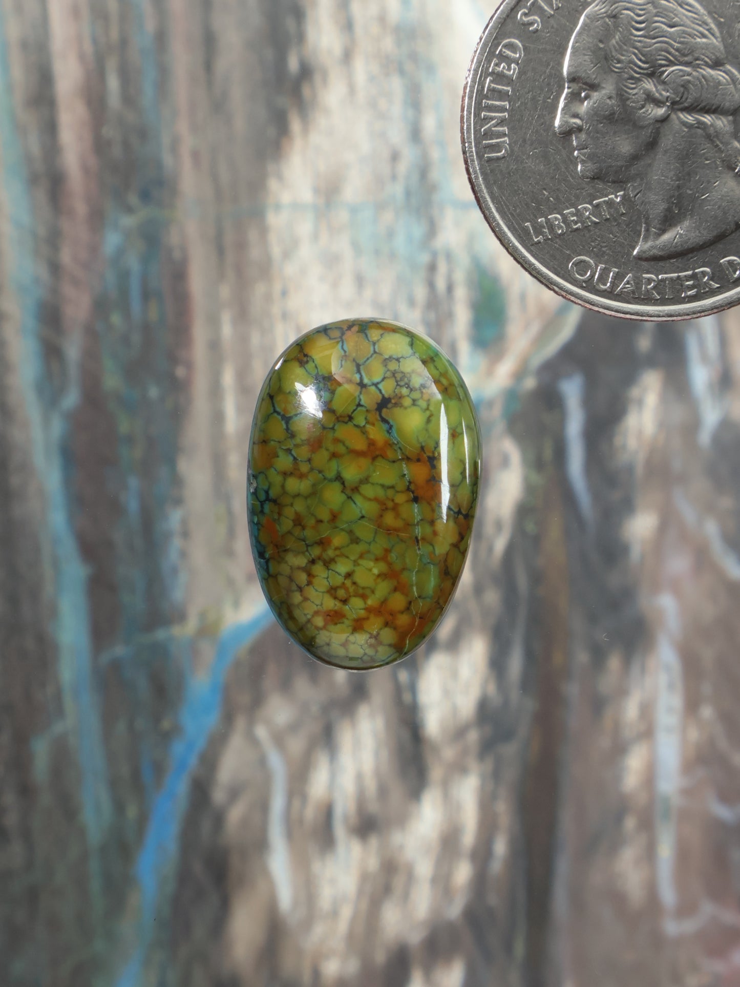 Oval turquoise cabochon gemstone with green-yellow matrix pattern