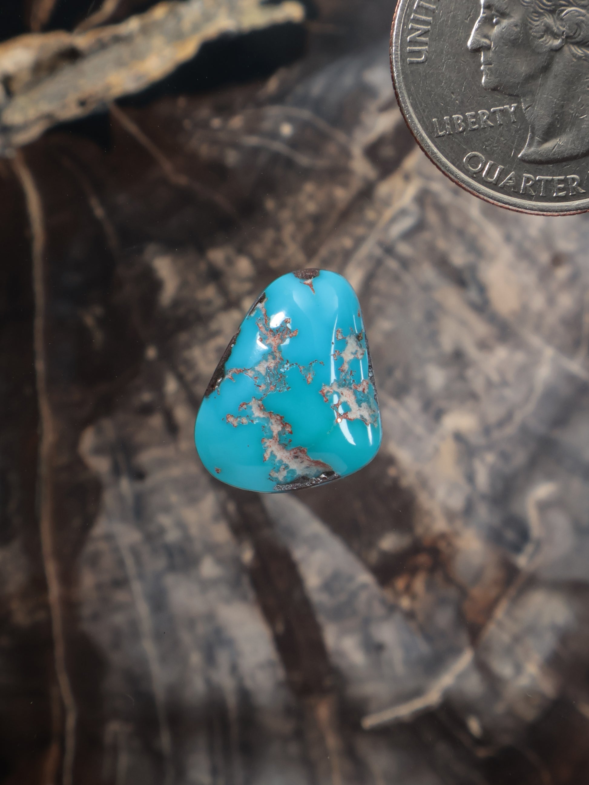 Turquoise cabochon gemstone with blue center and gold matrix, teardrop shape