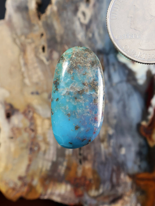 Oval turquoise cabochon with blue-green matrix and glossy polished surface
