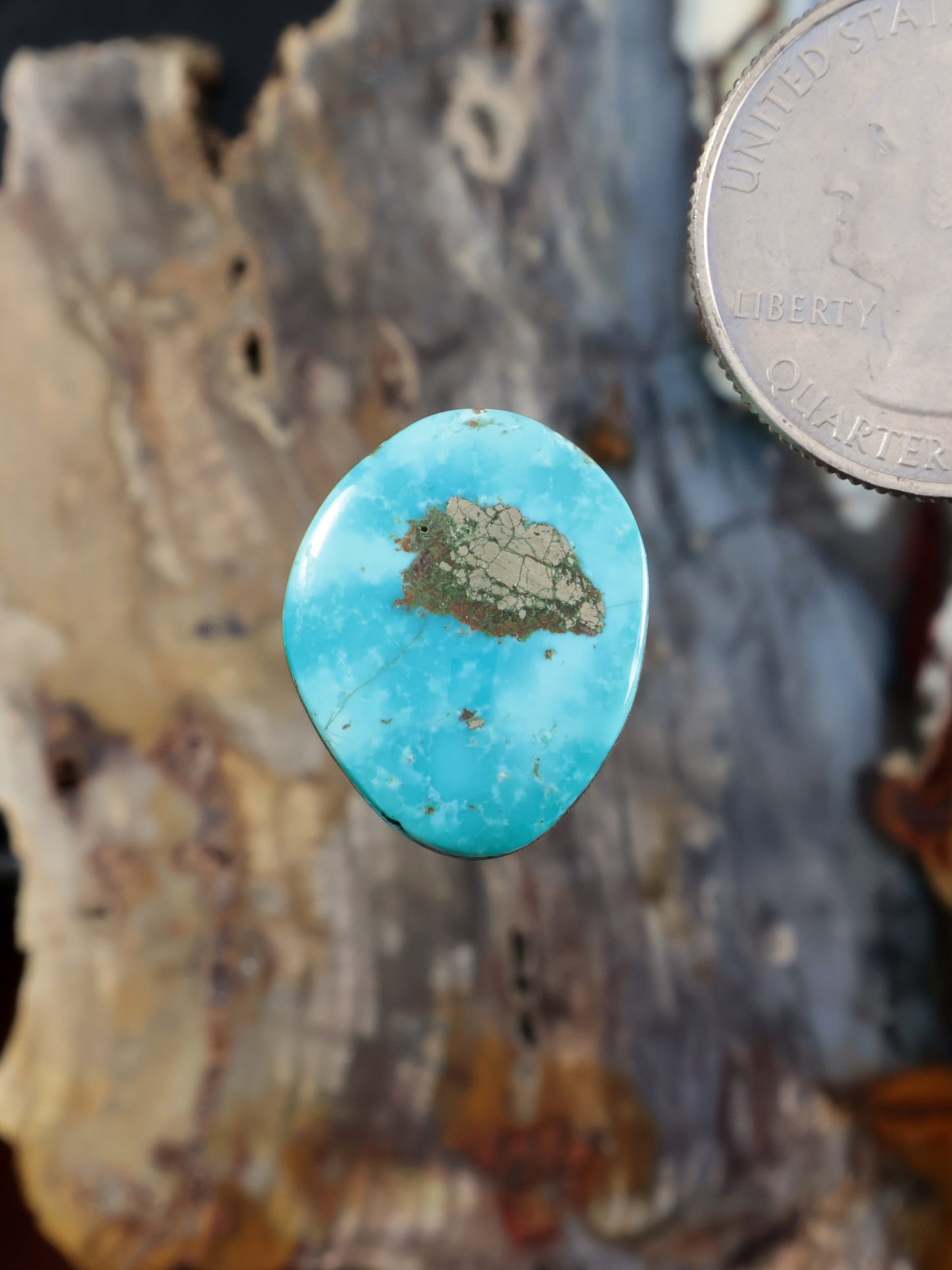 Turquoise cabochon gemstone with dark matrix inclusions