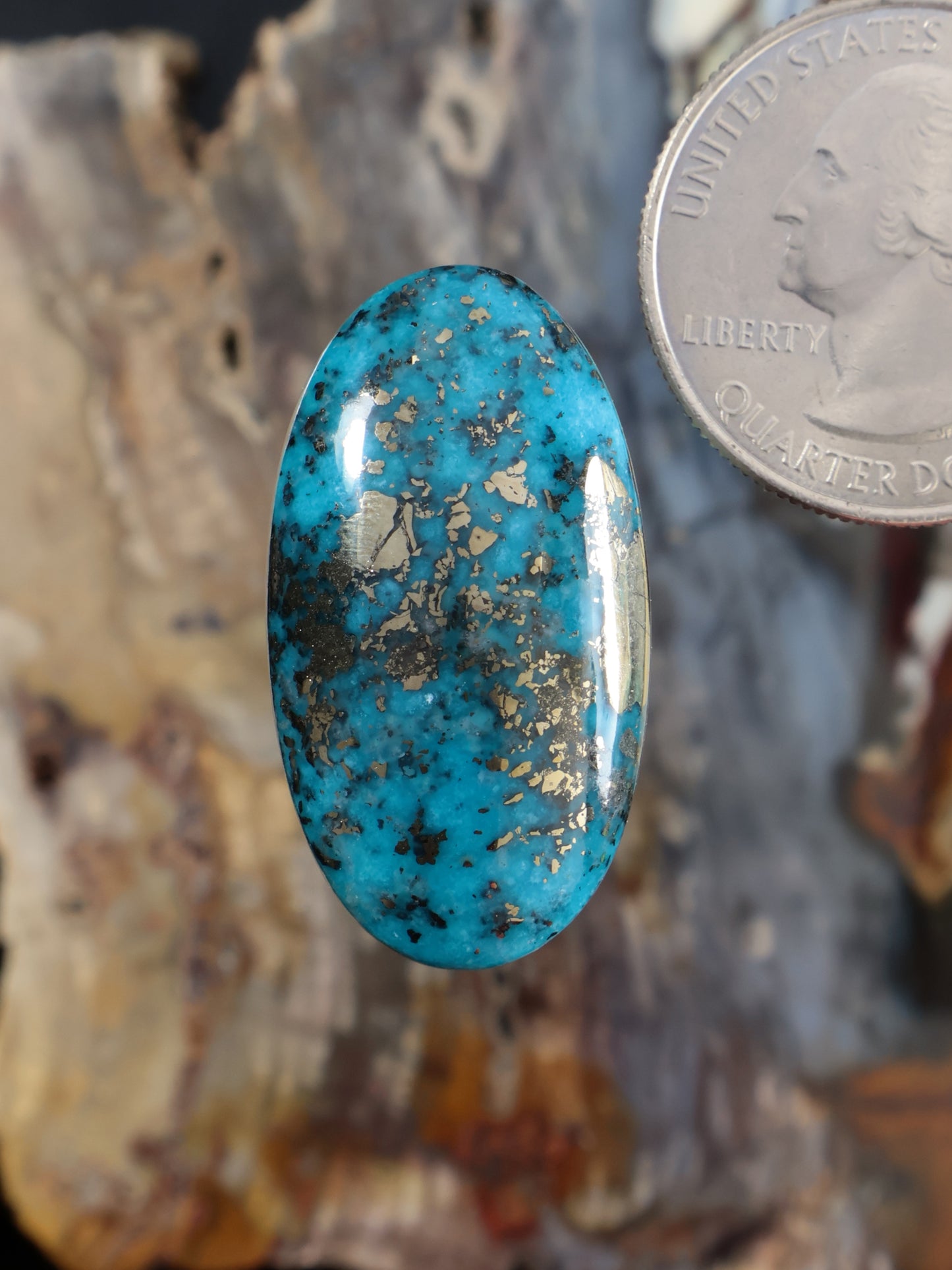 Oval turquoise cabochon gemstone with natural speckled matrix