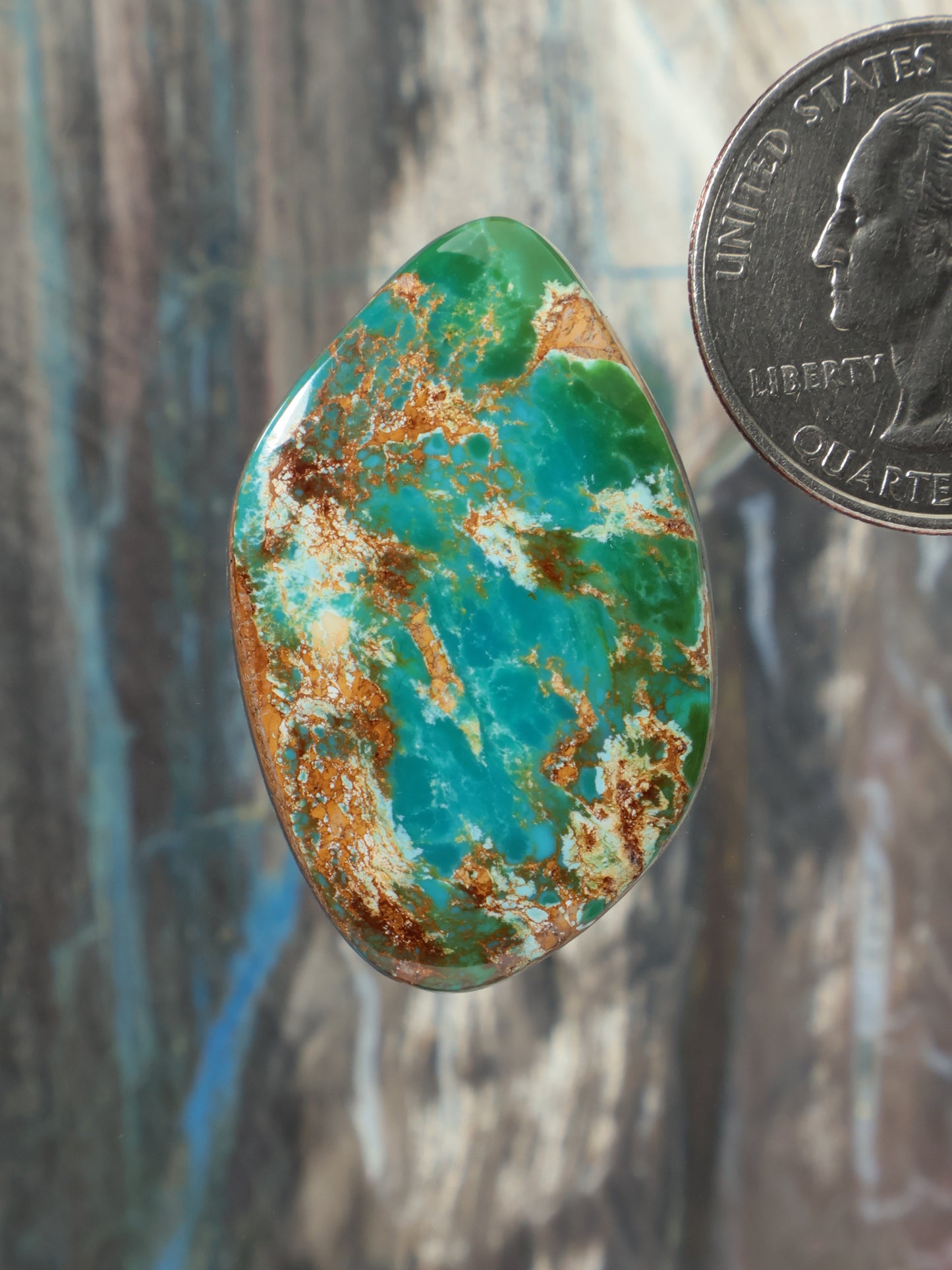Oval turquoise cabochon gemstone with green and brown matrix veining