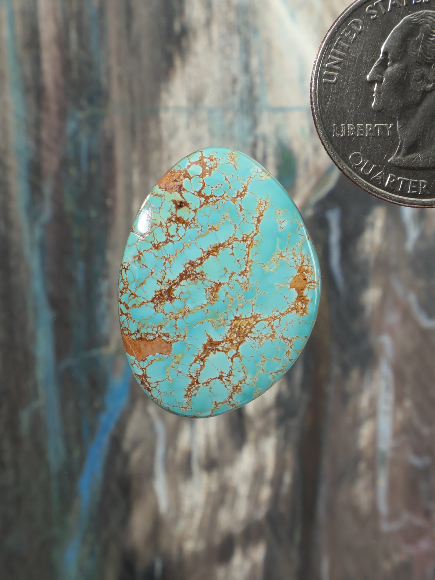 Oval turquoise cabochon gemstone with gold matrix veining