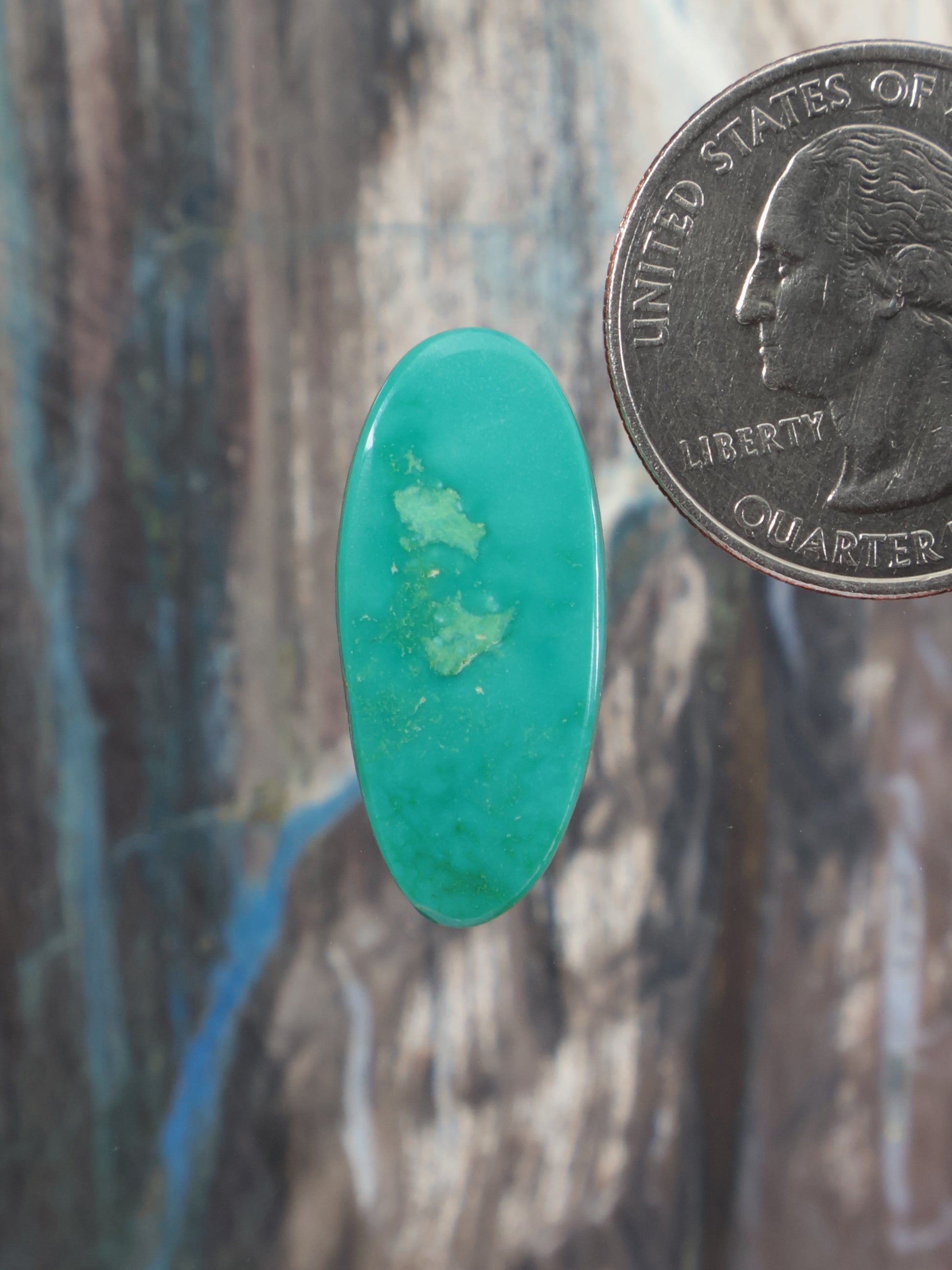 Oval turquoise cabochon gemstone with natural mottled inclusions