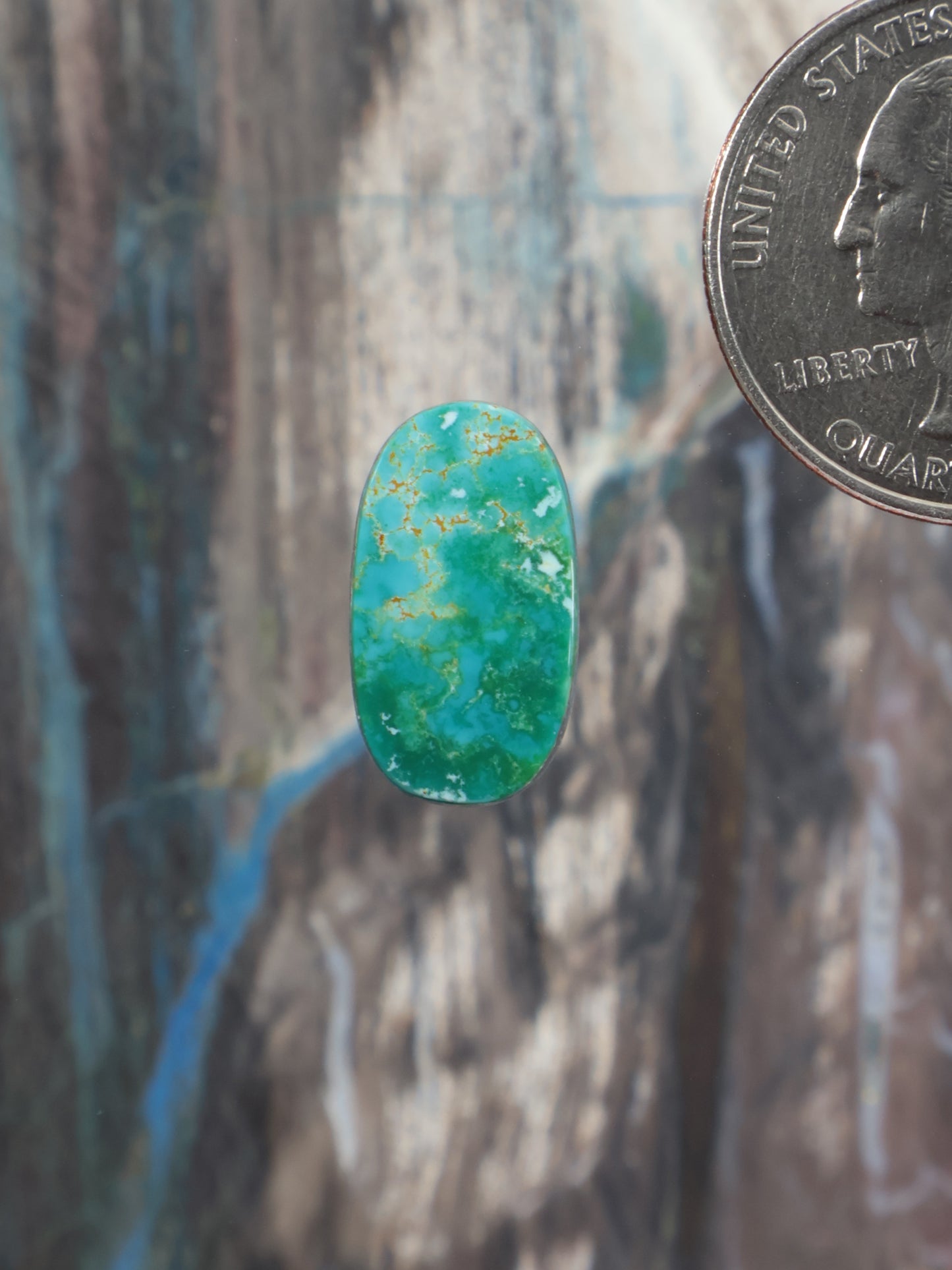 Turquoise oval cabochon gemstone with subtle gold veining