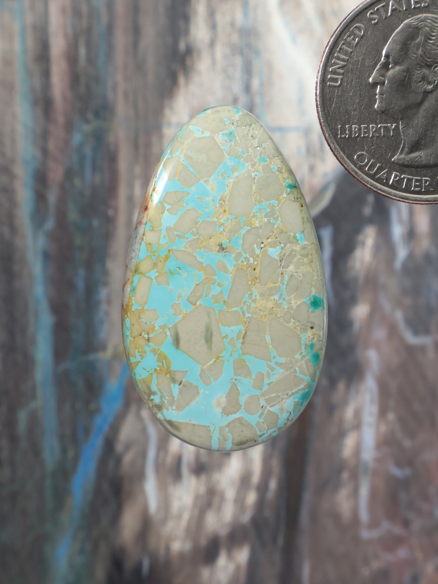 Turquoise cabochon oval gemstone with gold-speckled matrix pattern