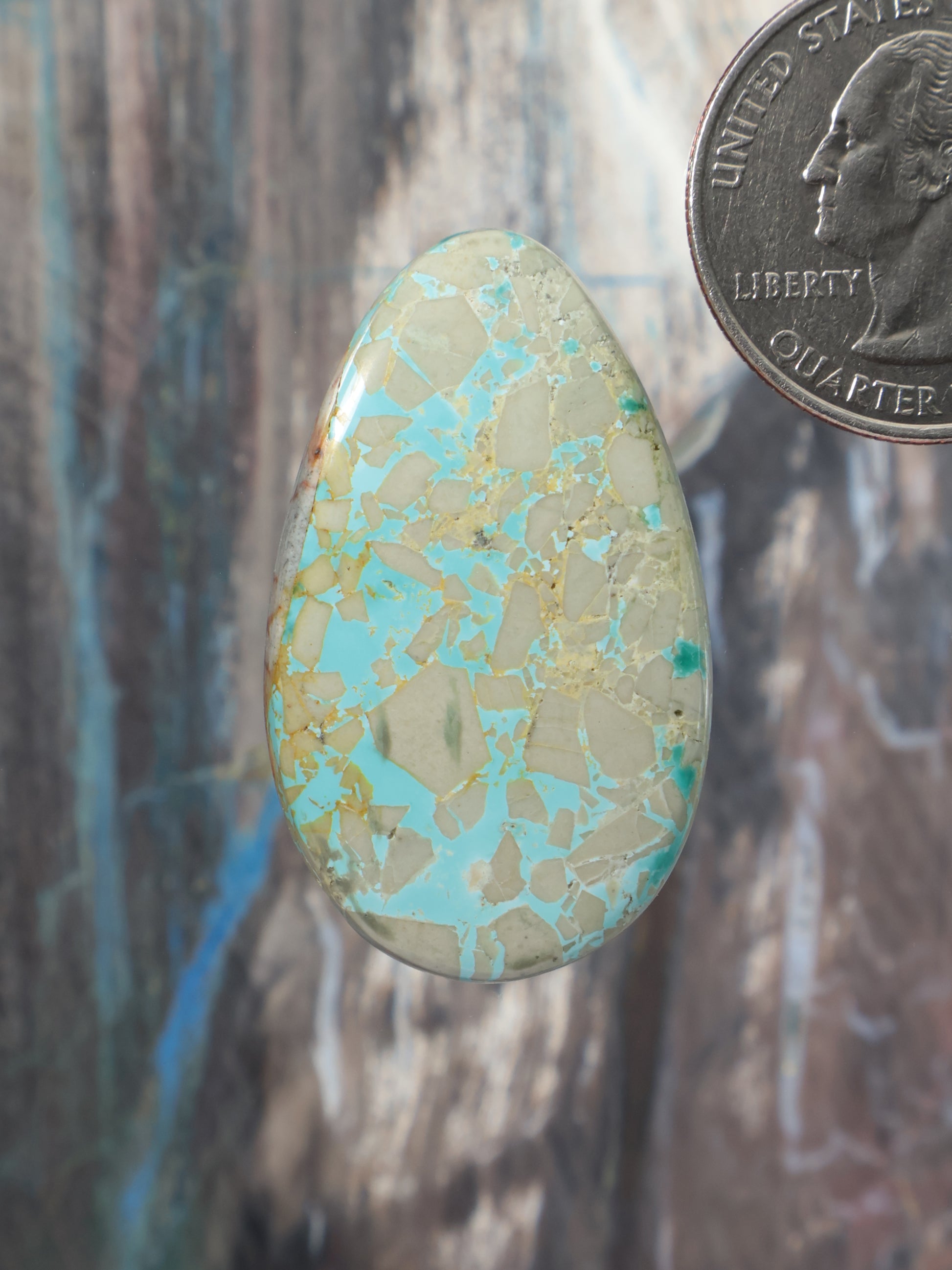 Turquoise cabochon oval gemstone with gold-speckled matrix pattern